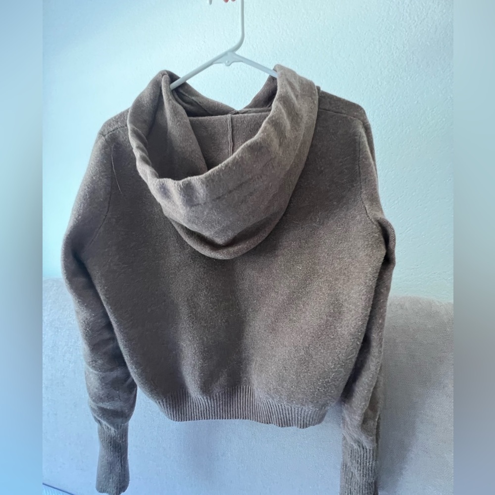 Cropped light brown sweater. Has a hoodie and long sleeves.